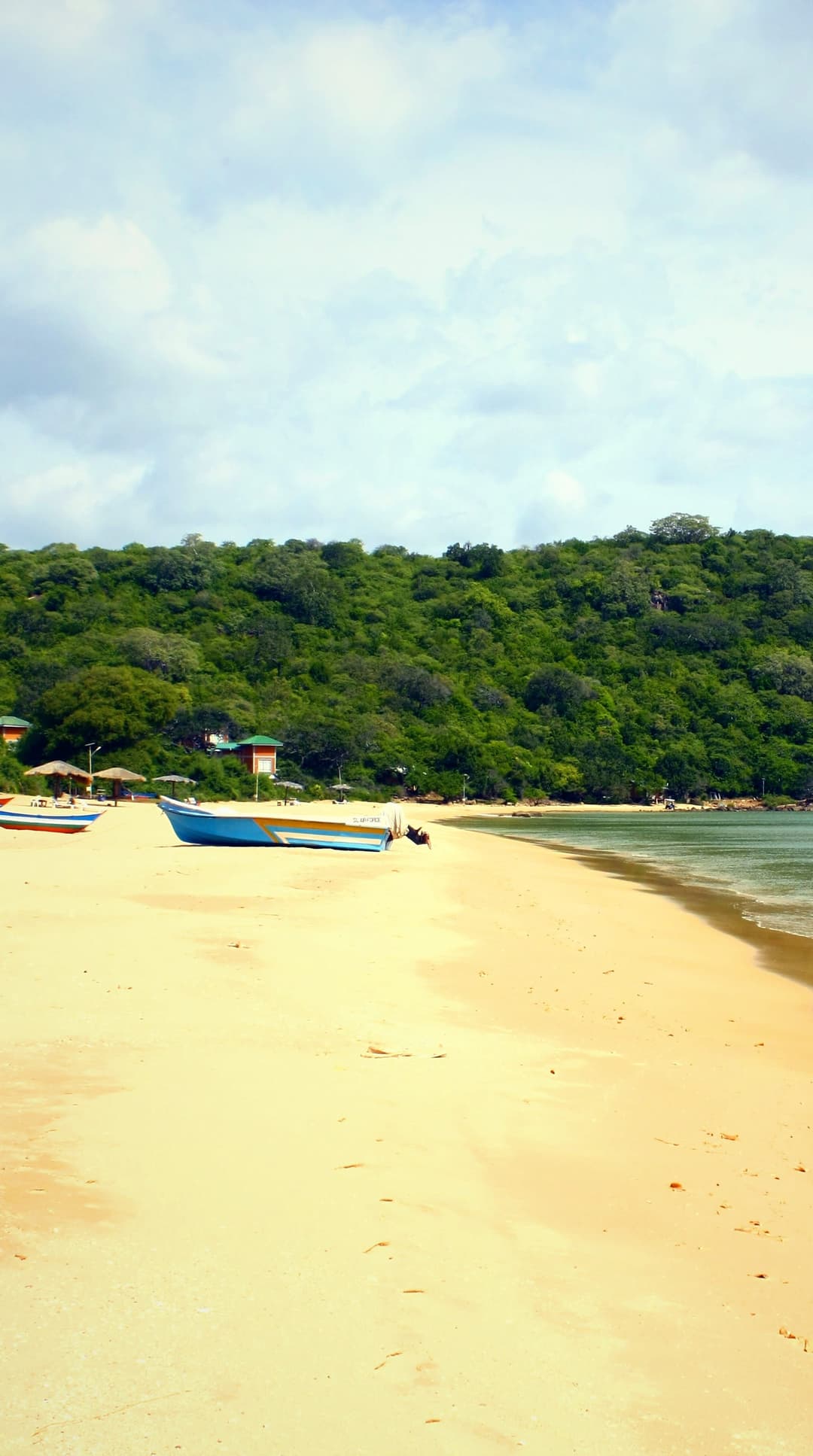 Marble Beach near Trincomalee: an empty sweep of pale sand, a wooded headland and clear, still water