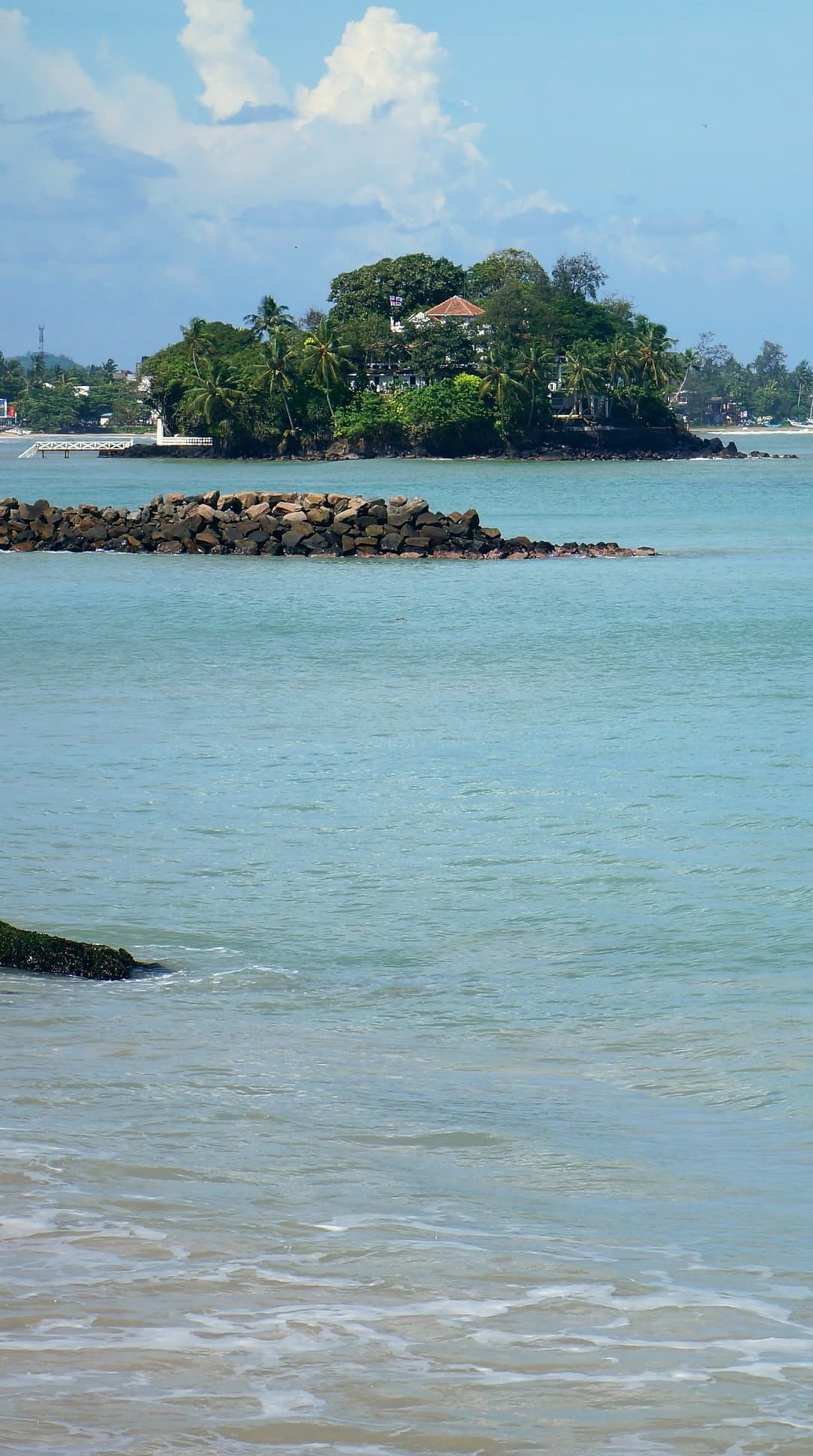 Weligama bay in clear blue water, with Taprobane island and its villa off the shore