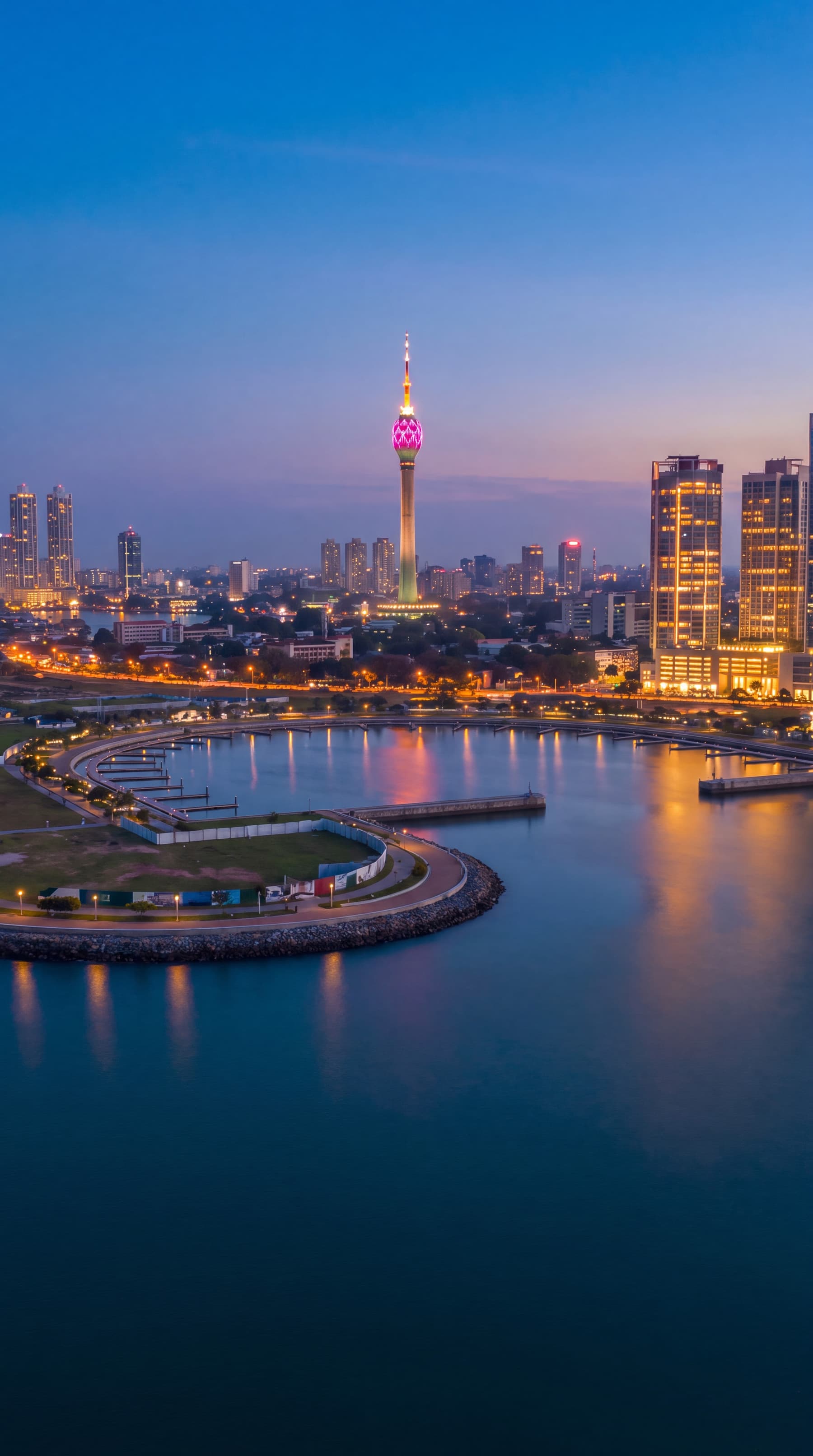 The Colombo skyline at dusk from the air, the Lotus Tower lit above Beira Lake