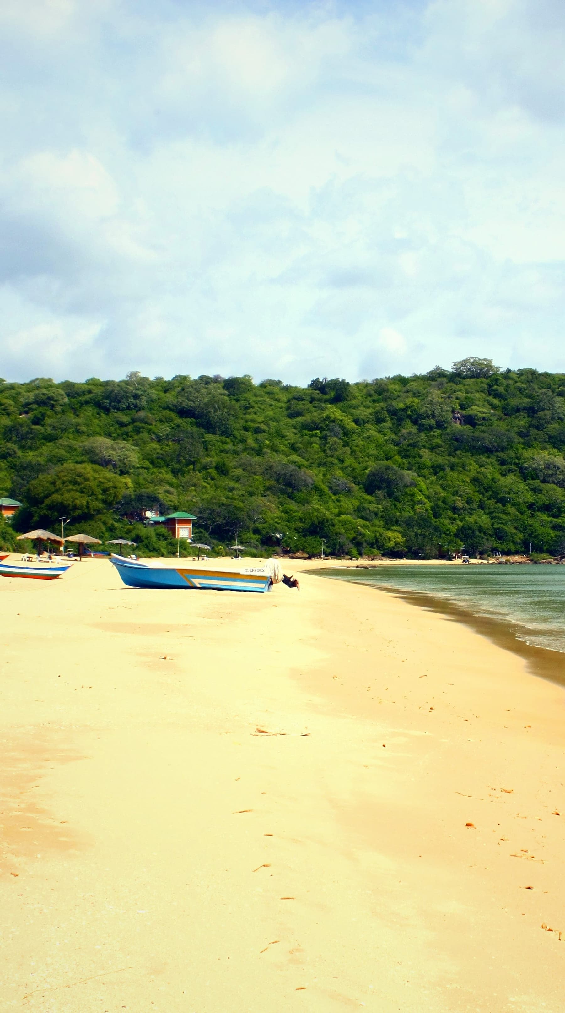 Marble Beach near Trincomalee: an empty sweep of pale sand, a wooded headland and clear, still water